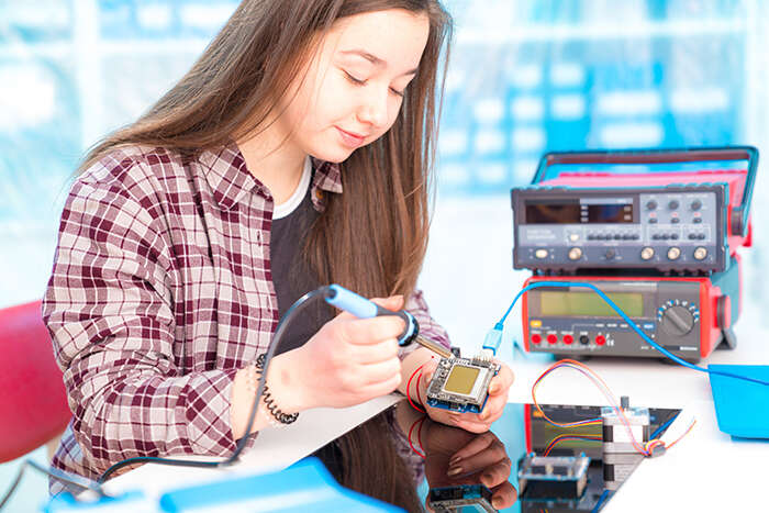A young female student soldering