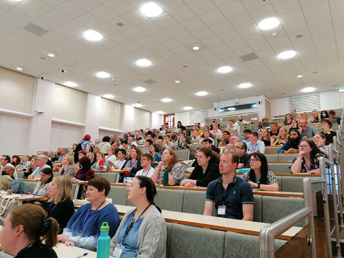 Audience members sitting in a lecture theatre