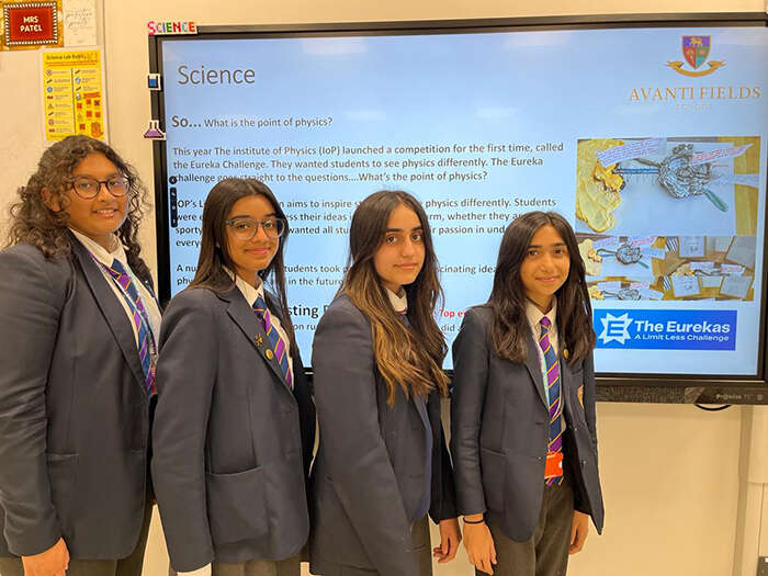 IOP Eurekas science competition winners smiling in front of a screen
