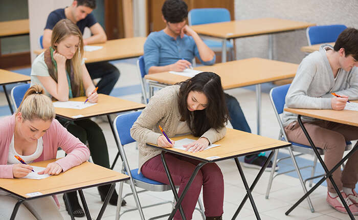 Physics A-level students sitting exam in hall