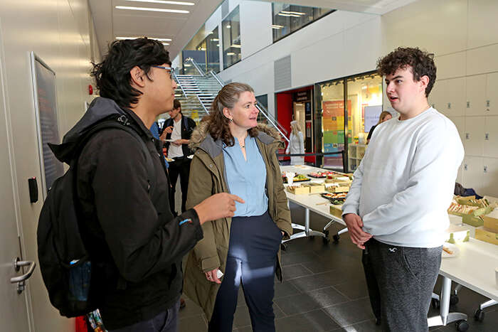 Dr Lisa Jardine-Wright chatting to physics students Henry Wang and James Swarbrick