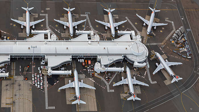 An aerial shot of seven grounded planes at a terminal at Sydney Airport